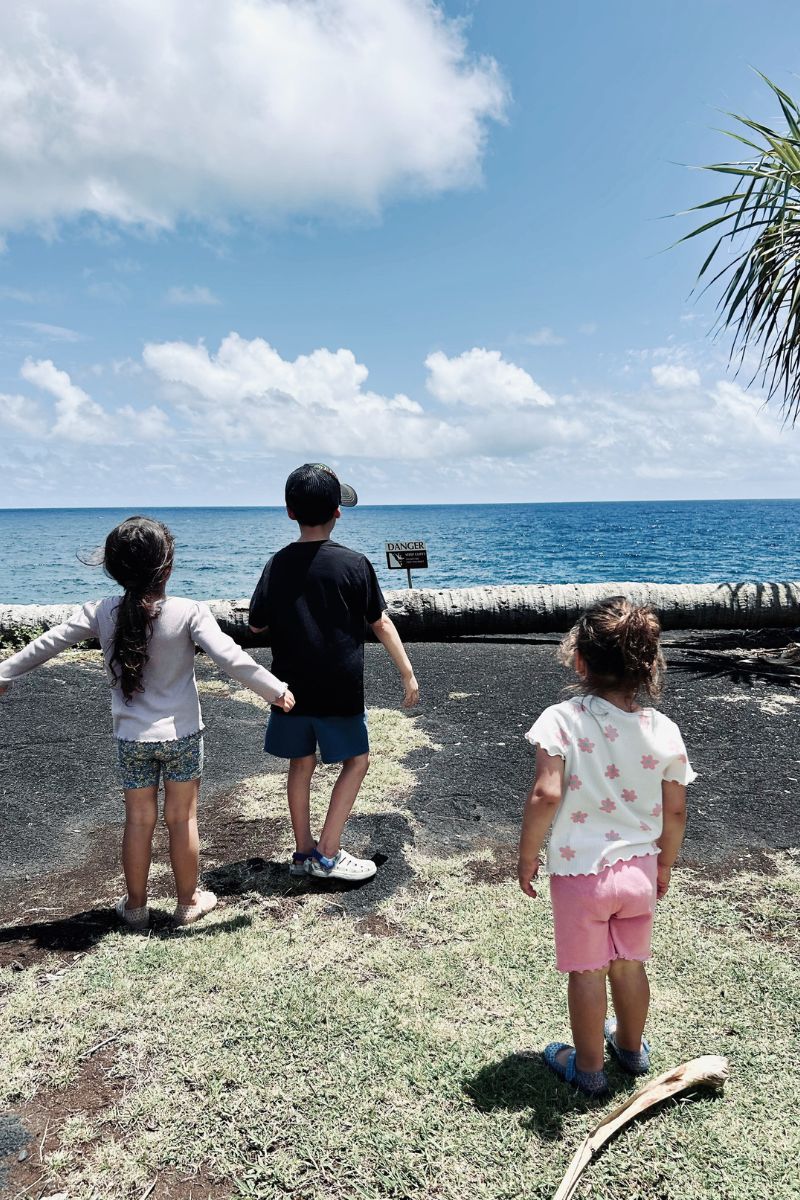 kids on cliffside over looking ocean